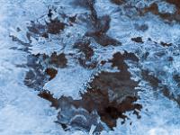 Offene Stelle in der Eisschicht im Lochgrabenbach mit Eisfiguren am Rand